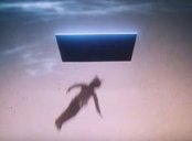 A young boy falls through a flat rectangular portal in the sky at dawn.