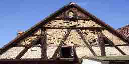 The flaking plaster-covered gable of an old Tudor roof.