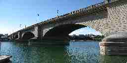 A long stone brick bridge arching across an Arizona river.